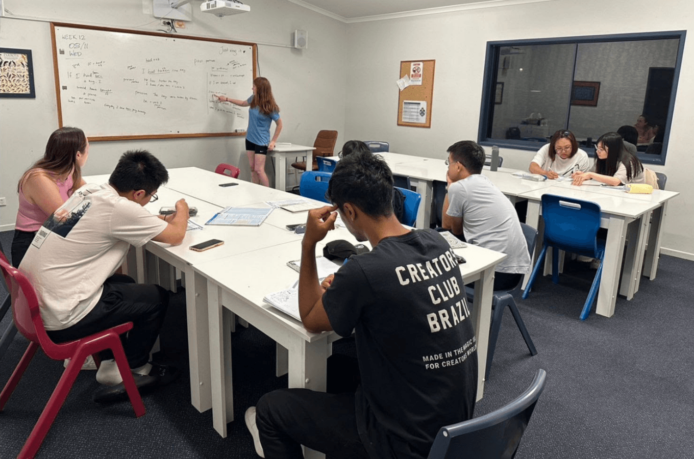 澳洲語言學校推薦：SPC (Sun Pacific College) 互動式小班英語課堂，專業教師在白板前熱情授課，引導學生分組討論，有效突破台灣學生不敢開口說英文的痛點。