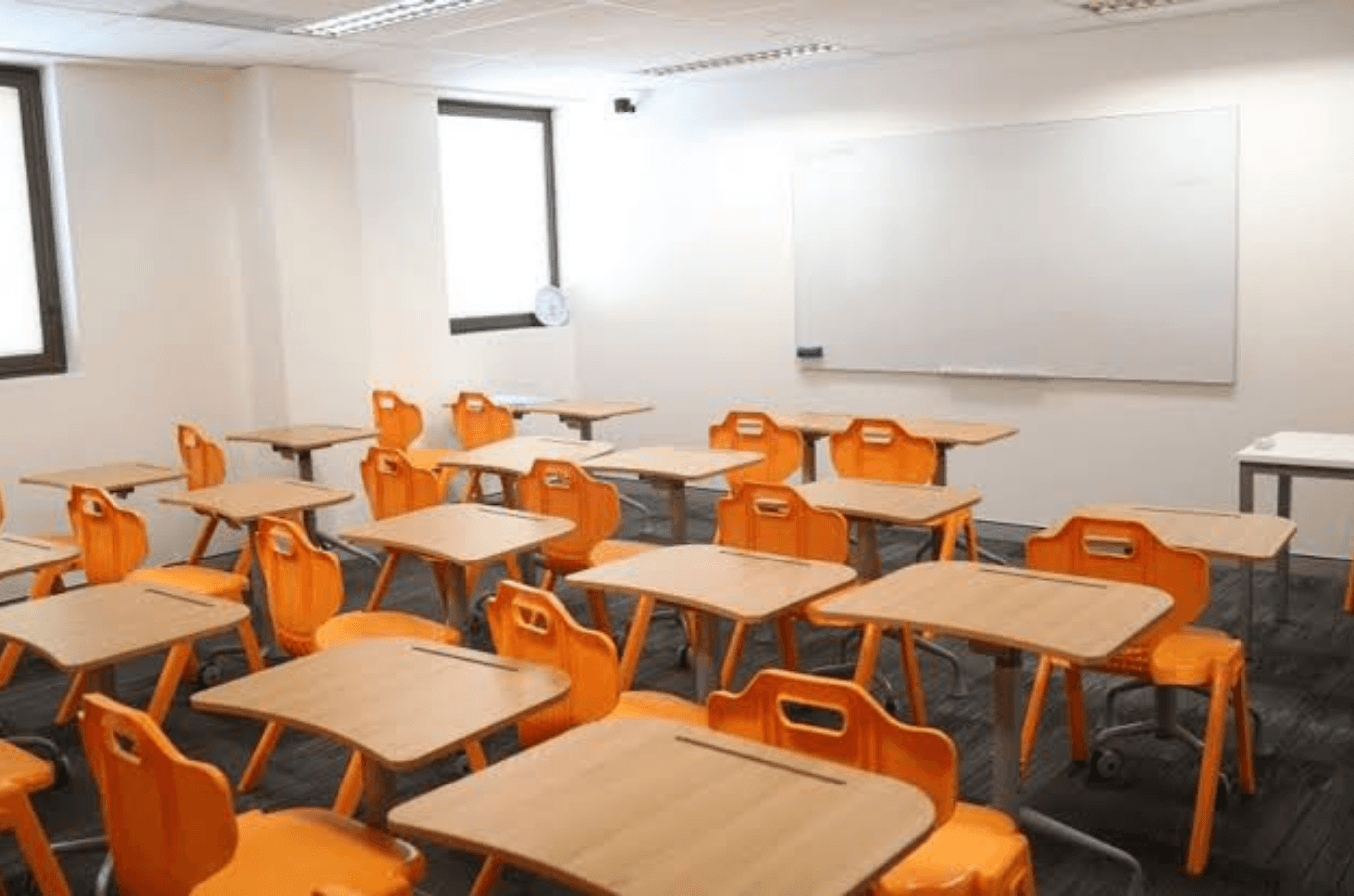 English Unlimited 舒適乾淨且現代化的教學教室：亮橘色的繽紛課椅設計搭配充足的室內採光，為遊學生與背包客提供專注高效、充滿活力的英語學習硬體設施。