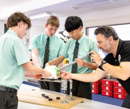 STEM 機器人與工程實作課：學生在老師指導下組裝機械模型。學校設有現代化科技實驗室，透過動手做讓孩子克服不敢開口說英文的恐懼，培養未來創新能力。