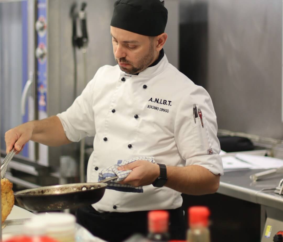 澳洲 ANIBT 專業廚藝實作訓練：學員身穿完整 Chef 廚師制服於商業級廚房進行烹飪操作，培養扎實的職場實務技能